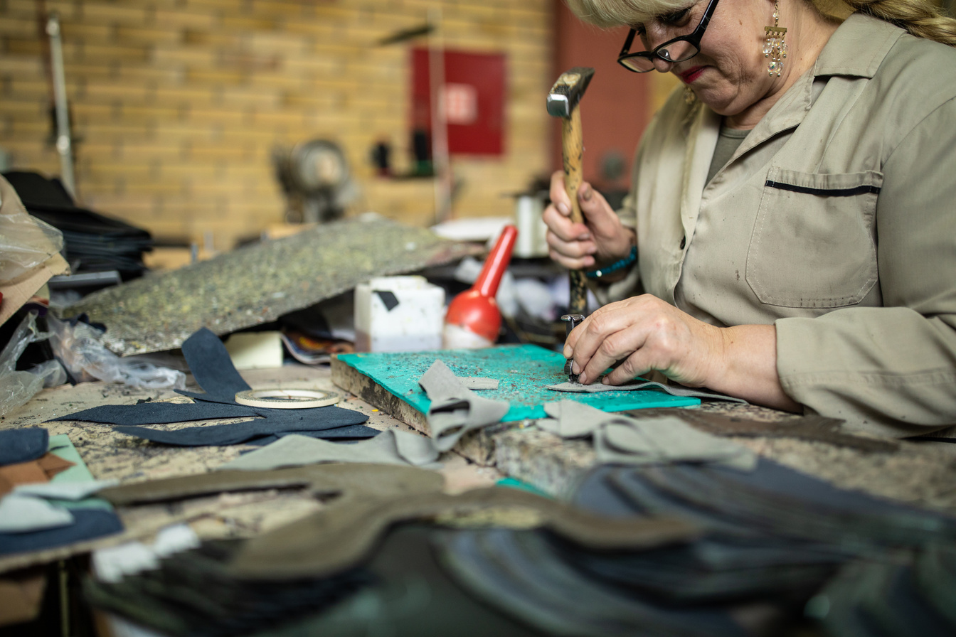 Blond Woman using hammer in shoe manufacturing